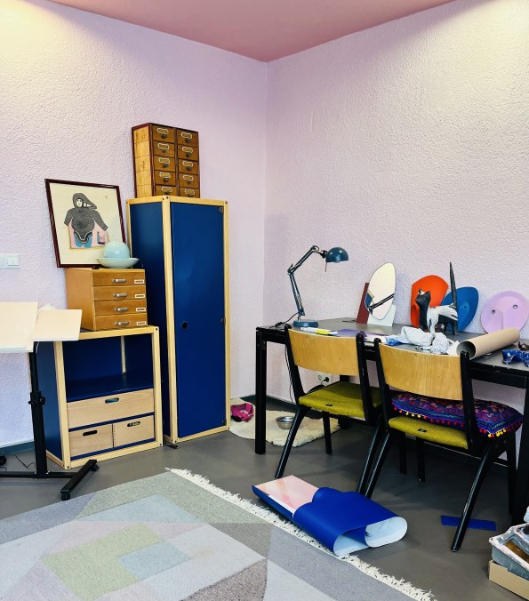 Therapieraum mit Tisch, Stühlen und blauem Schrank